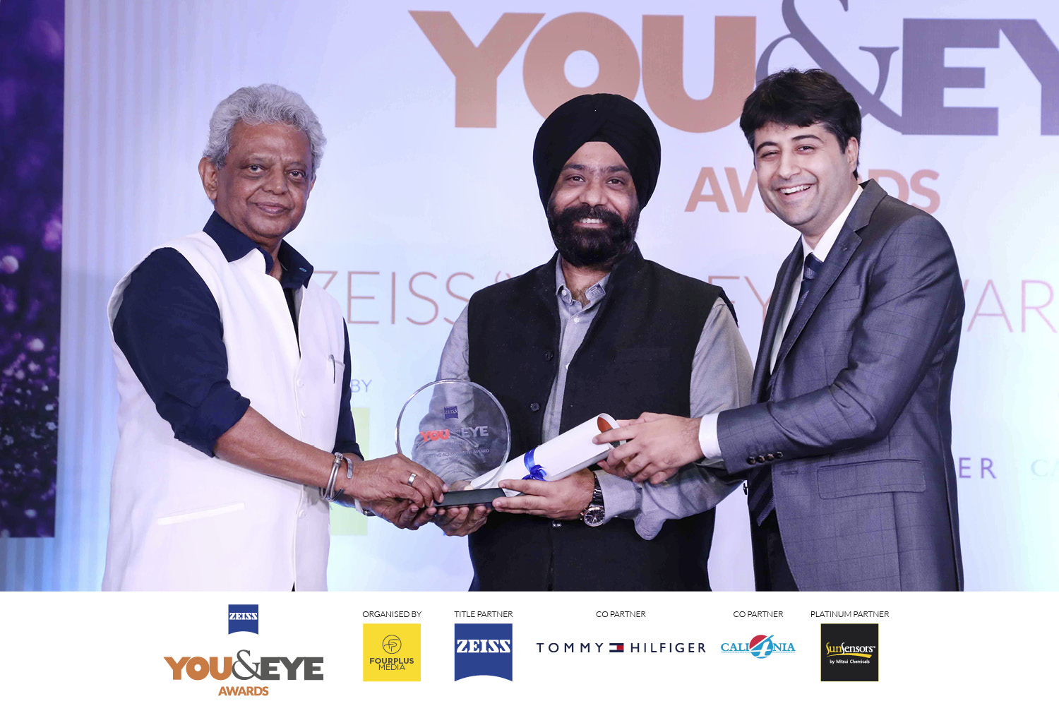 Jaspreet Singh, Titan Company Ltd accepting the award on behalf of Shree Ronnie Talati from Siraj Bolar, CEO, FourPlus Media and Rohan Paul, ZEISS